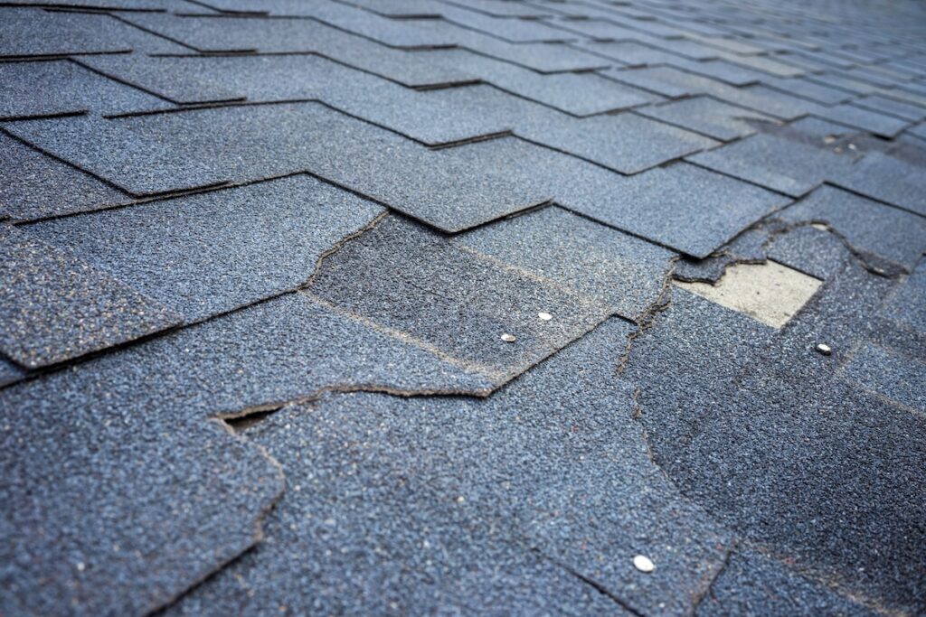 Сlose up view of bitumen shingles roof damage
