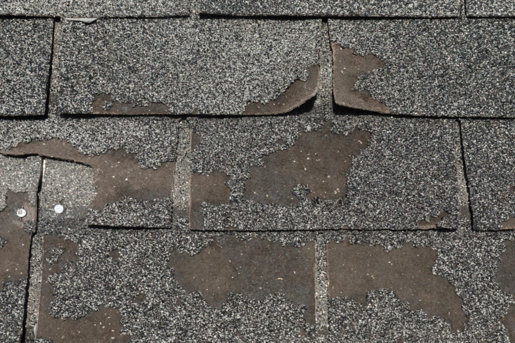 signs of hail damage on roof Roof in need of repair damaged asphalt roofing shingles architecture construction background texture pattern abstract concept