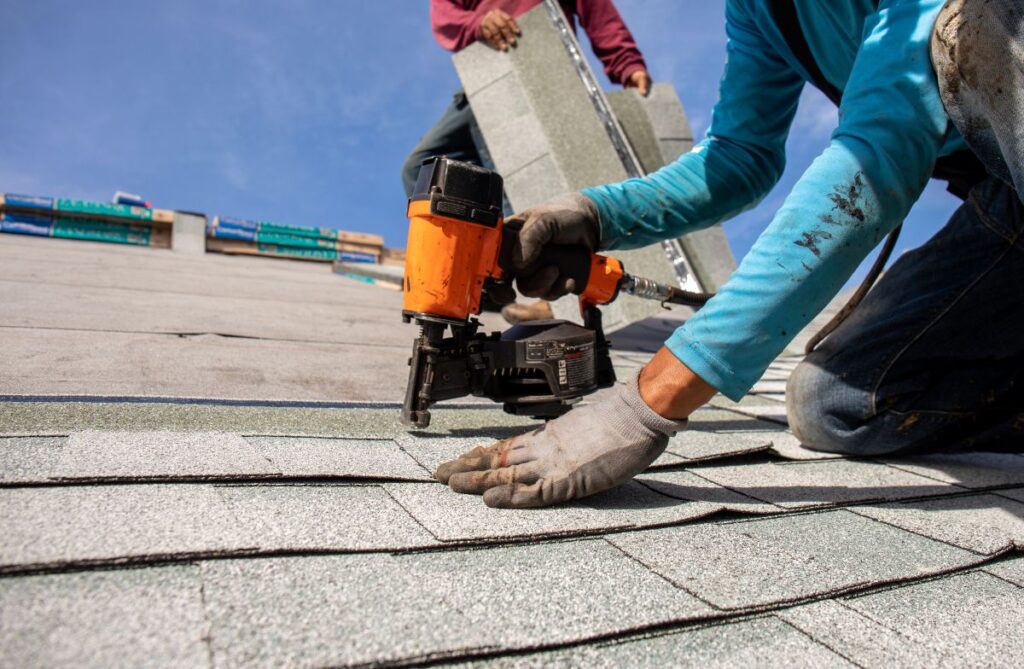 roofer install roof shingles with nail gun